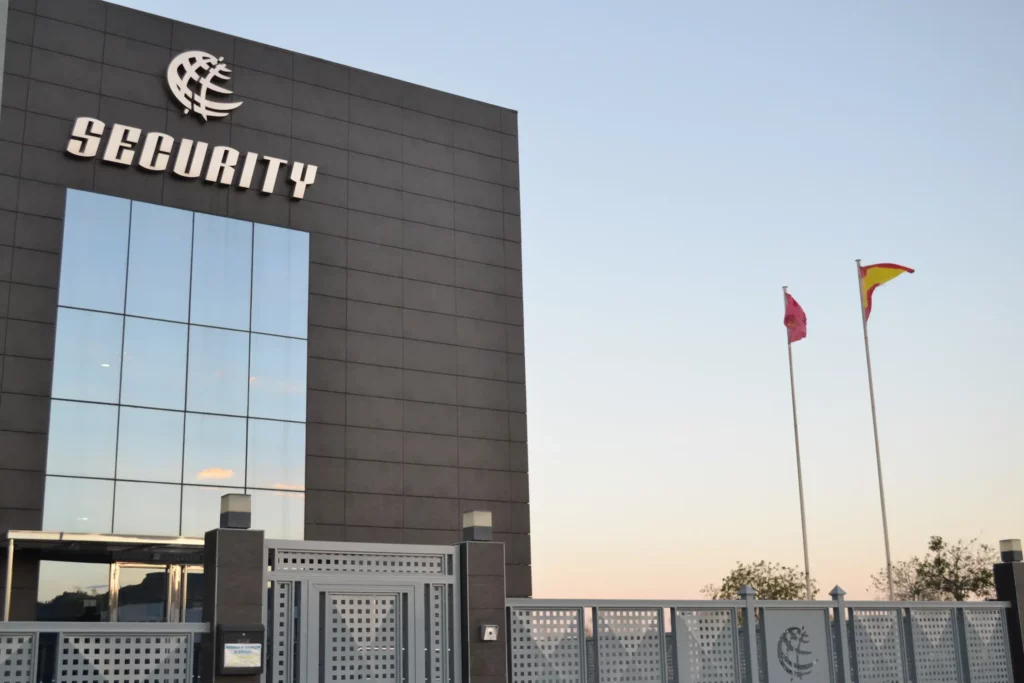 Fachada del edificio sede de Grupo Security al atardecer con las banderas de España y de la Región de Murcia ondeando